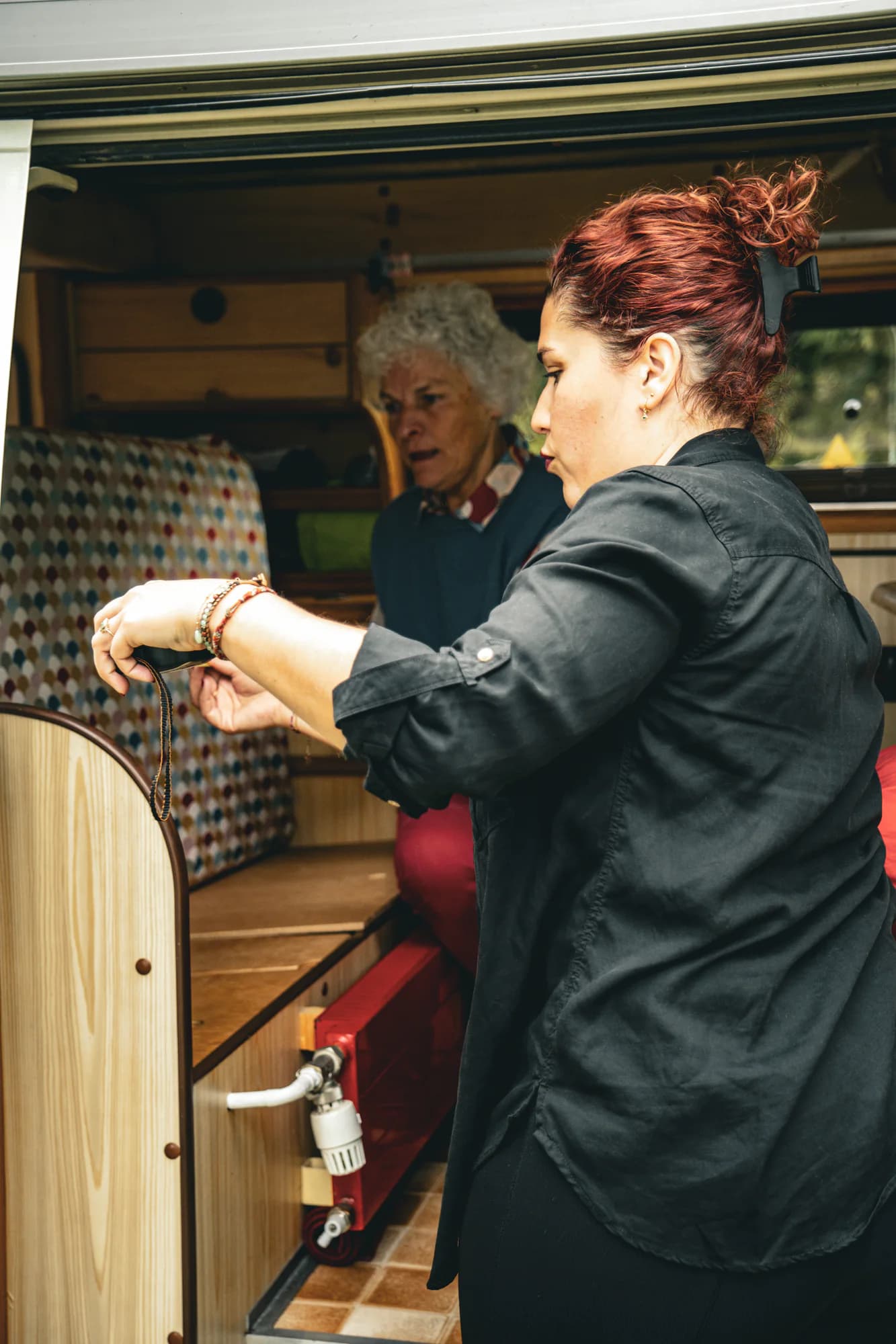 Solène prend les mesures d’une banquette dans un van aménagé.