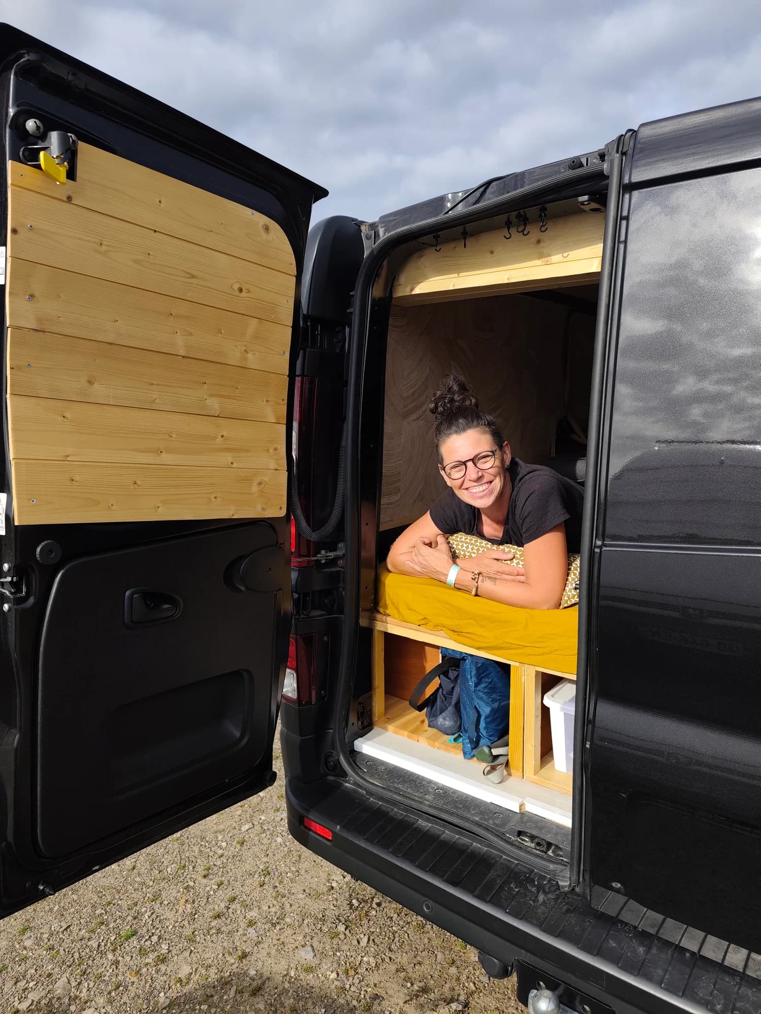 Valérie sourit depuis le couchage installé à l’arrière du van.