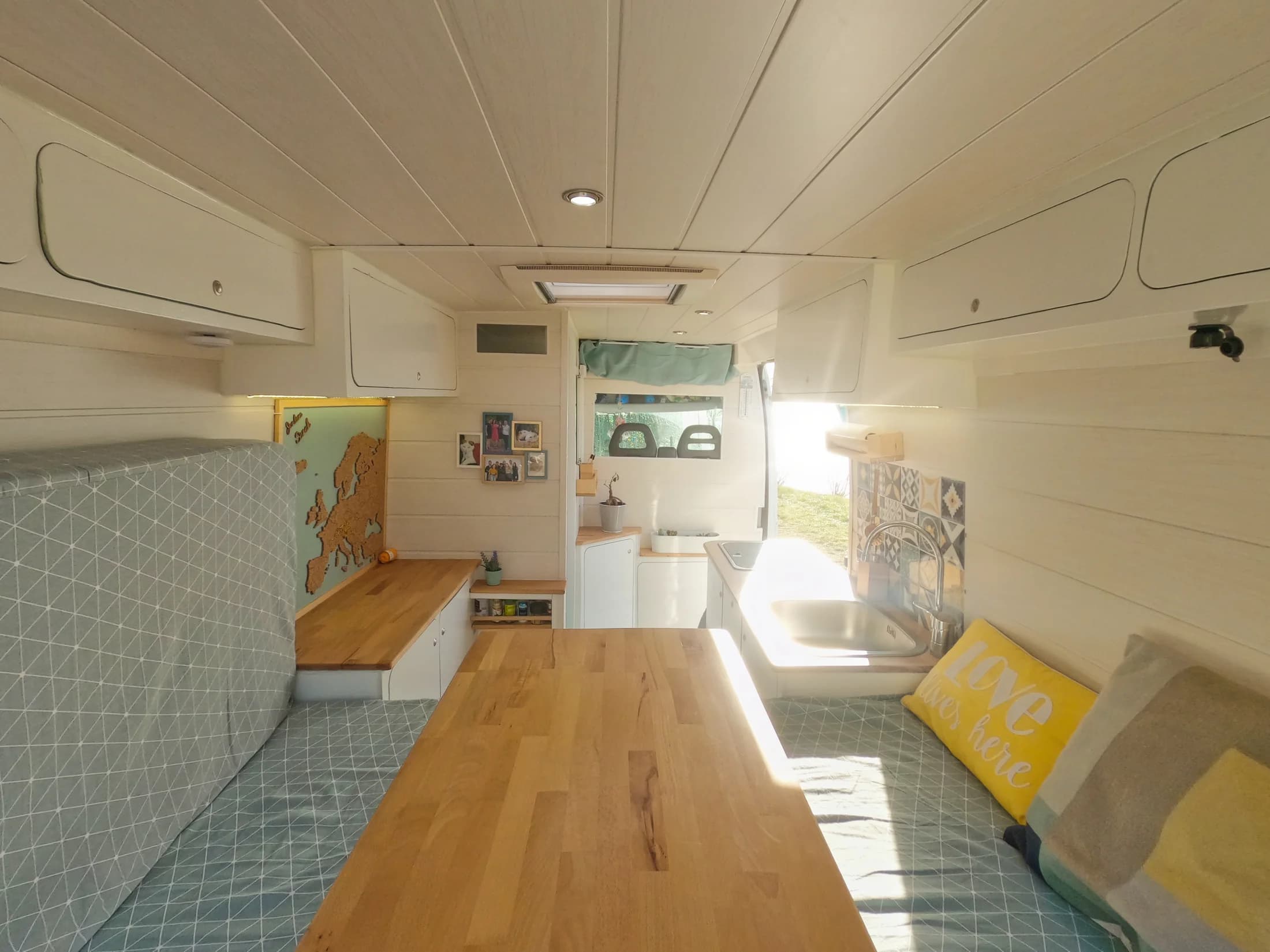Intérieur en bois clair du fourgon aménagé par Sarah et Jordane